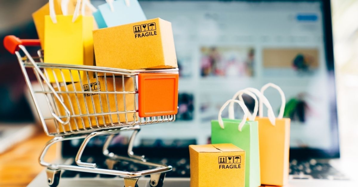 Achats pendant les soldes : sacs et chariot et site internet en arrière plan