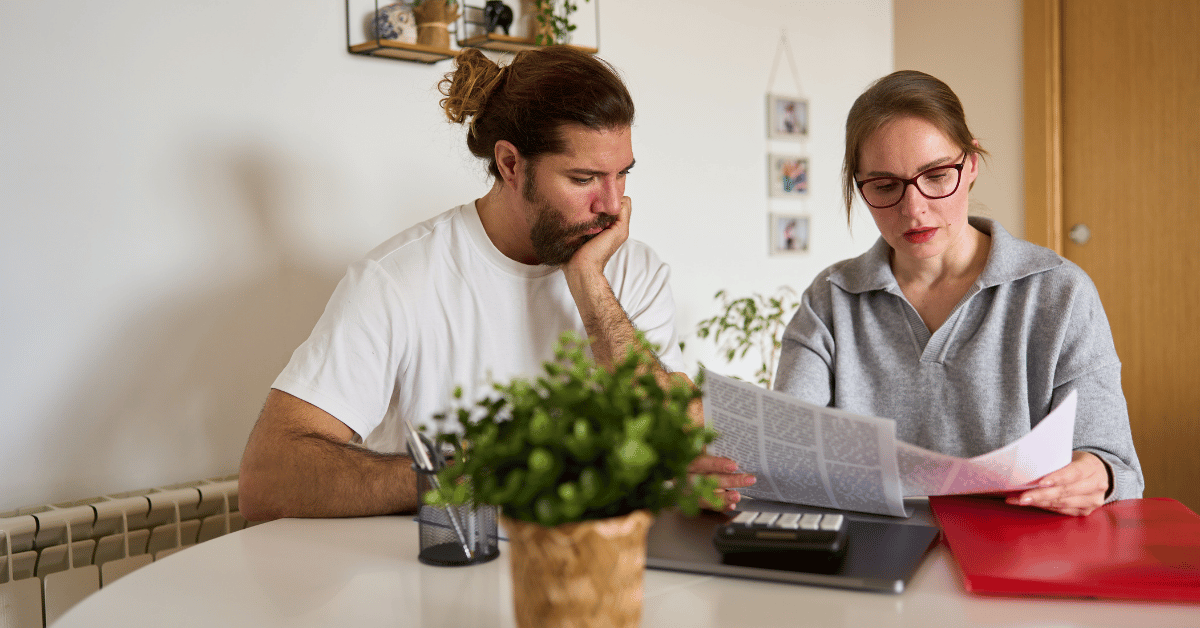 Couple inquiet devant des documents de prêt immobilier