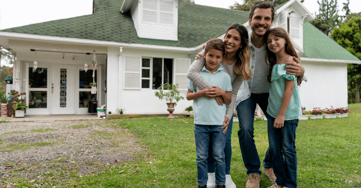 Famille souriante devant leur maison