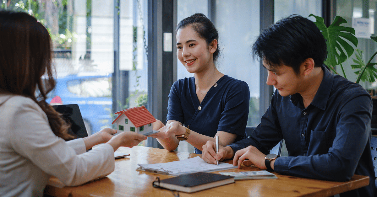 Jeune couple signant un contrat immobilier chez notaire